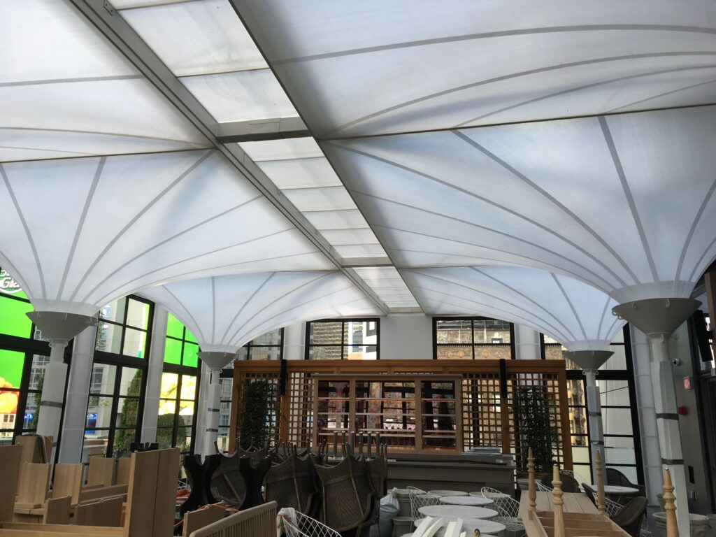 Translucent architectural fabric canopy over an interior dining space
