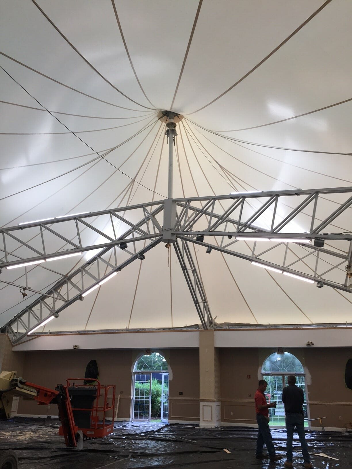 Interior of a tensile canopy, radial trusses meeting at a central mast